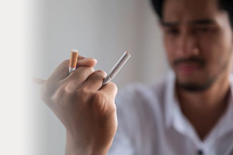 Man crushing cigarettes trying to quit tobacco